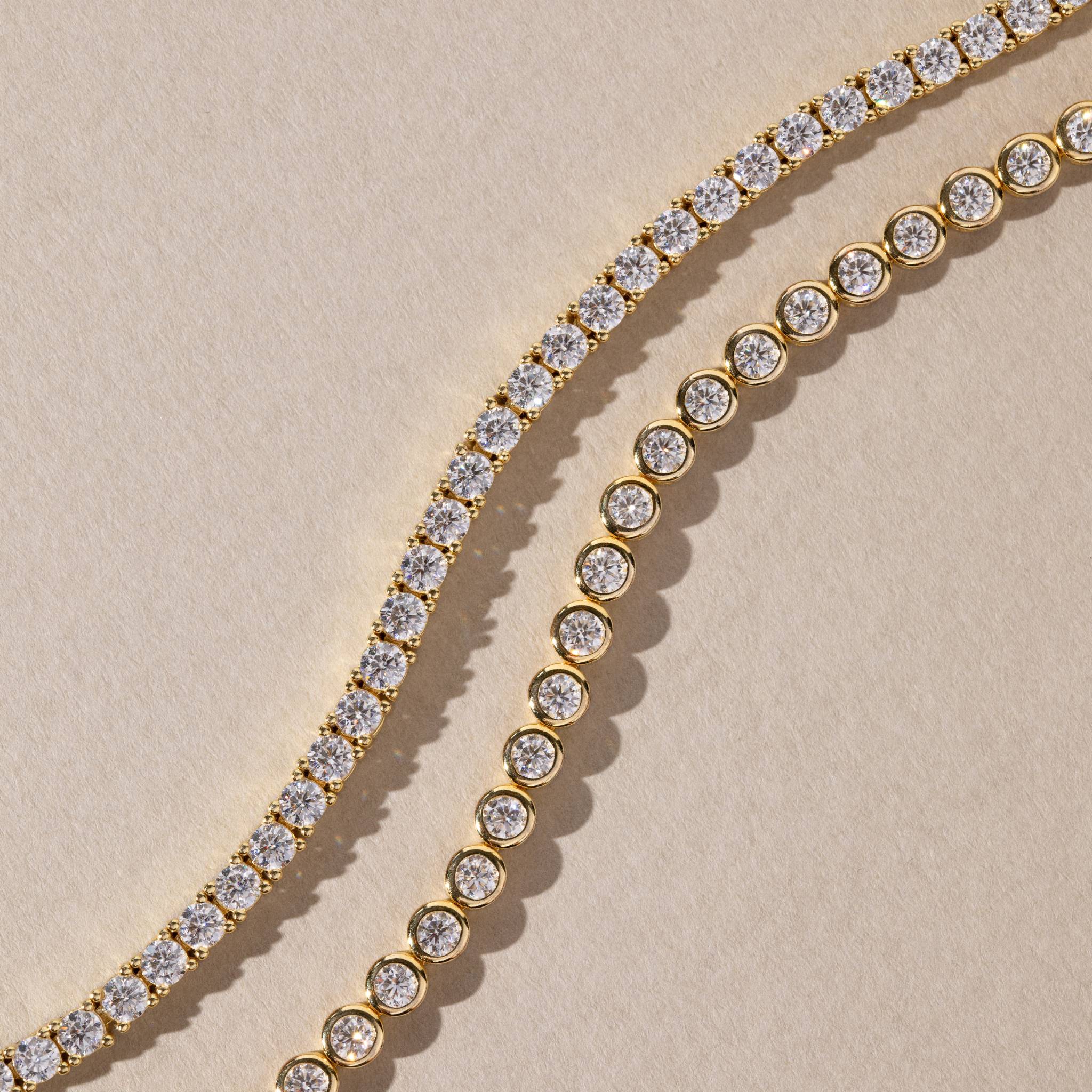 Gold and moissanite bracelet and necklace on a beige background