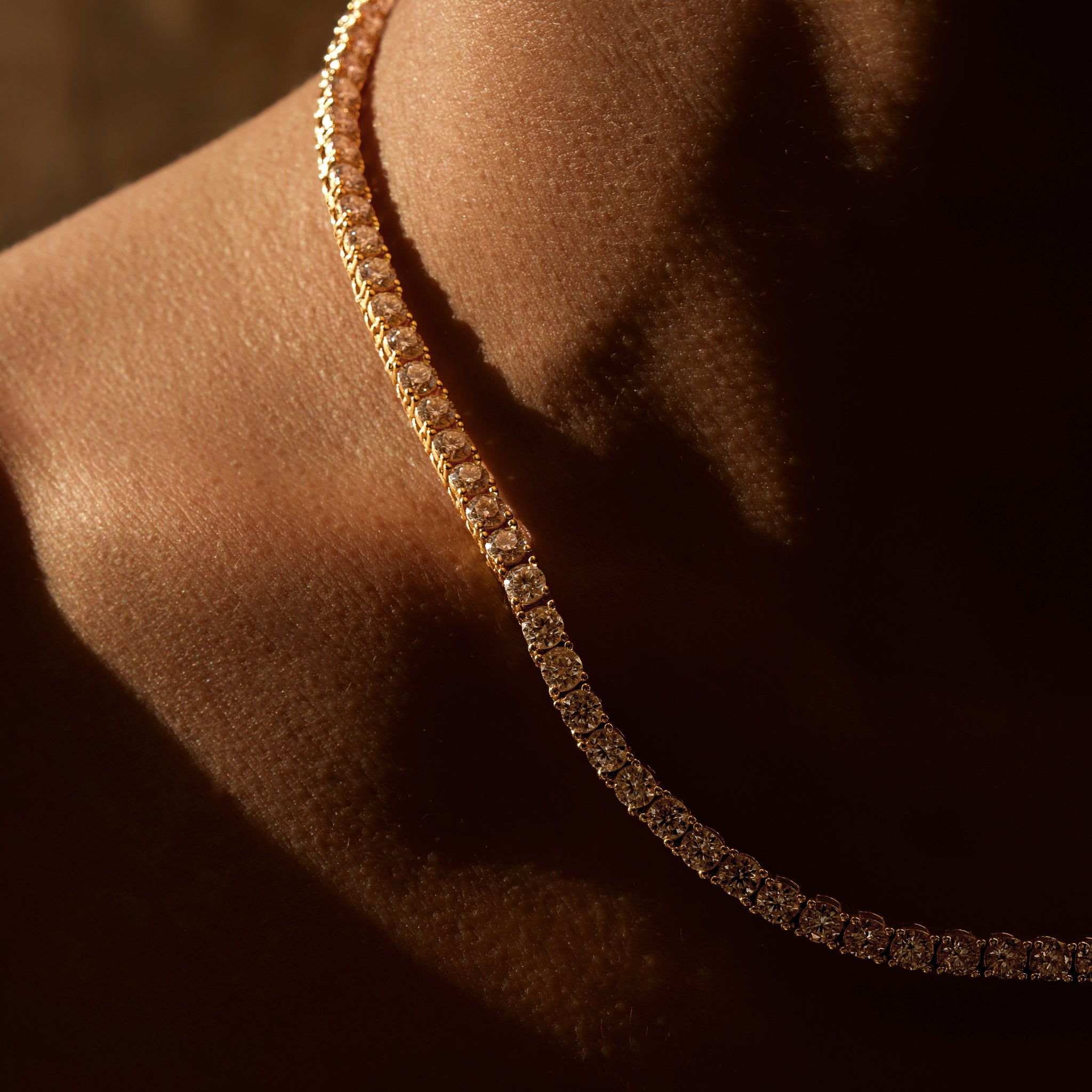 Gold necklace close up on bronzed female neck