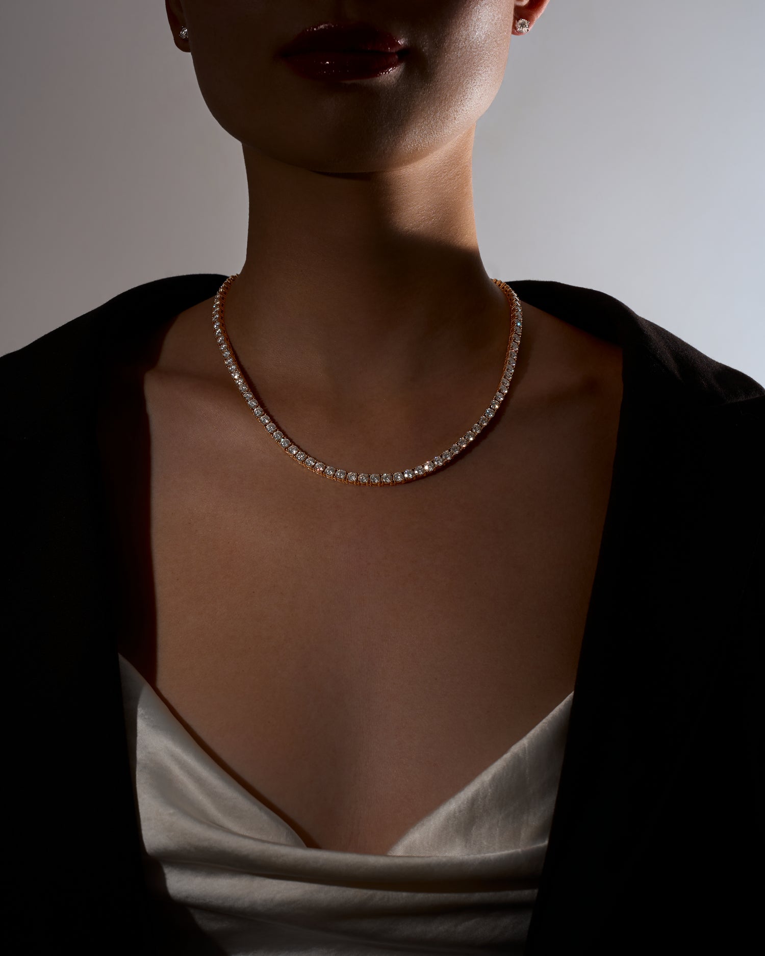 Sparkling moissanite necklace worn by a woman with a neutral background