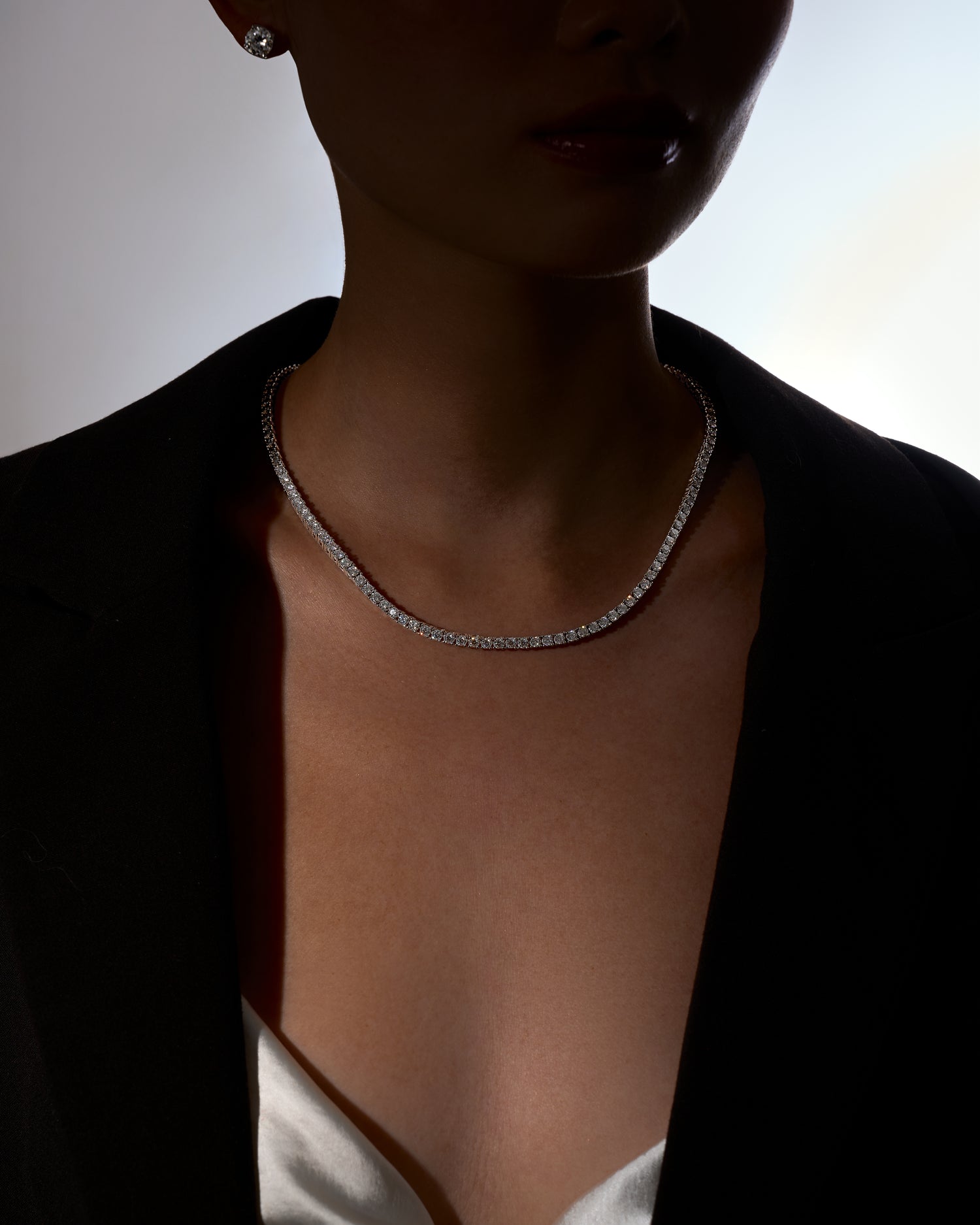 Woman wearing a moissanite necklace with a blurred background